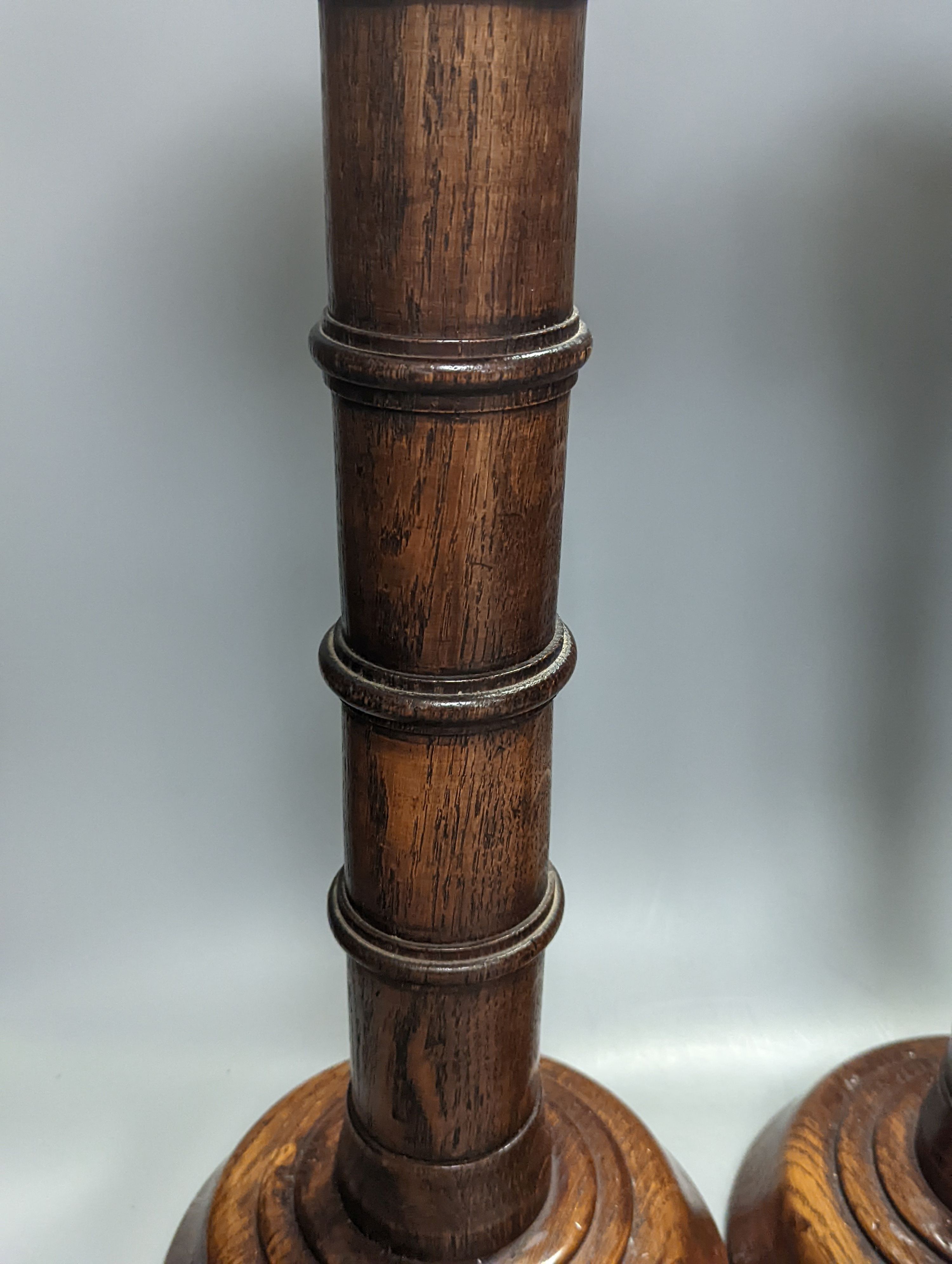 A pair of Pugin inspired Gothic style oak pricket candlesticks, height 56cm